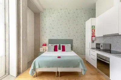 a bedroom with a large bed with red pillows at Charming Balcony Apartment in Historic Ribeira - Inside Porto Apartments 