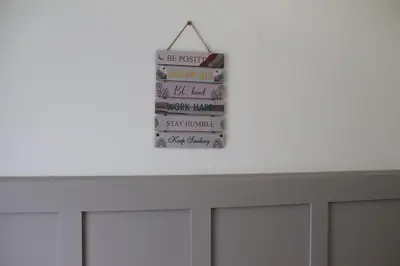 a sign hanging on a wall above a white table at Mirandesa Garden in Porto