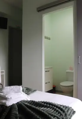 a bedroom with a bed and a bathroom with a toilet at Mirandesa Garden in Porto