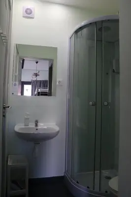 a bathroom with a glass shower and a sink at Mirandesa Garden in Porto