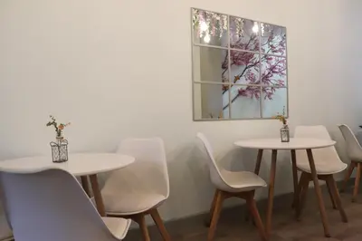 a room with white tables and chairs and a picture at Mirandesa Garden in Porto