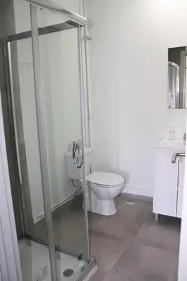 a bathroom with a toilet and a glass shower stall at Mirandesa Garden in Porto