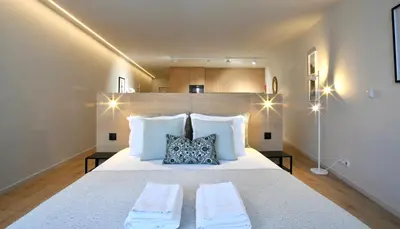a bedroom with a large white bed with two pillows at Oporto Coliseum Residence in Porto