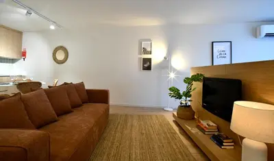 a living room with a couch and a television at Oporto Coliseum Residence in Porto