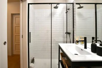 a bathroom with a shower and a white sink at Oporto Coliseum Residence in Porto
