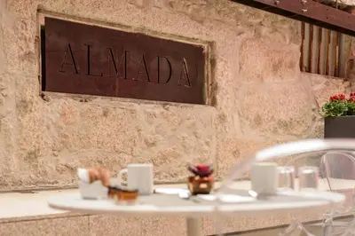 a table with a sign on a wall at Exe Almada Porto in Porto