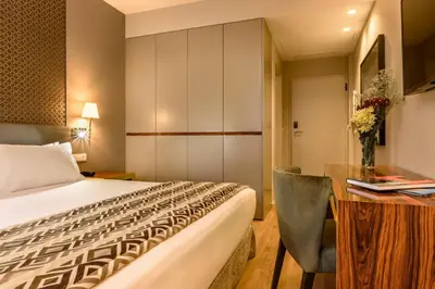 a hotel room with a bed and a desk at Exe Almada Porto in Porto