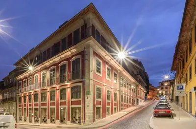 a building on the side of a street at night at Exe Almada Porto in Porto