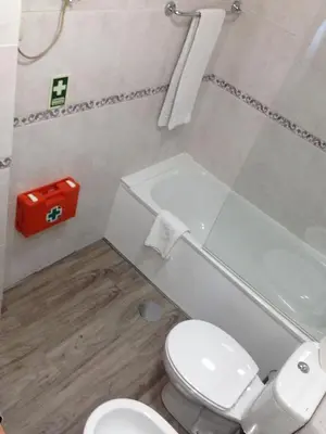 a bathroom with a toilet and a sink and a tub at Seculo apartments in Porto