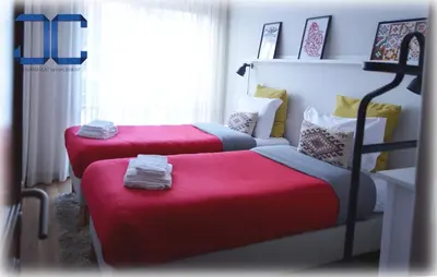 a bedroom with two beds with red sheets and a window at Country Apartment by JC in Porto