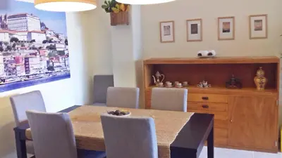 a dining room with a wooden table and chairs at Bombarda House & Home in Porto