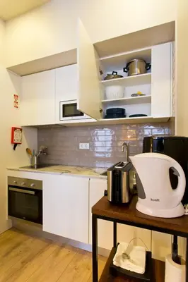 a kitchen with white cabinets and a mixer on a table at RVA - Sao Joao Novo Apartments in Porto