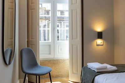 a room with a chair and a bed and a window at ORM - Bolhao Apartments in Porto