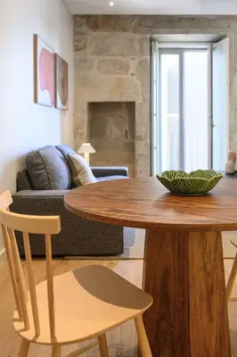 a living room with a wooden table and a couch at Pause Apartments in Porto