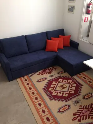 a blue couch in a living room with a rug at Lovely Mezzanine in Porto with FREE PARKING in Porto