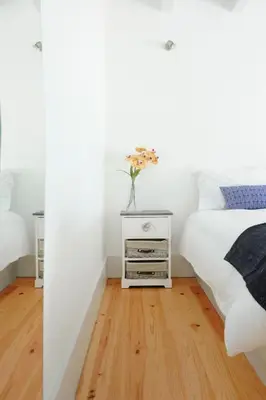 a bedroom with a bed and a vase of flowers on a night stand at Lovely Mezzanine in Porto with FREE PARKING in Porto