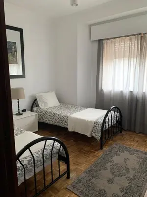 a bedroom with two beds and a window at A Casa das Margaridas in Porto