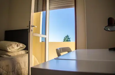 a room with a bed and a table and a window at Combatentes Apartment in Porto