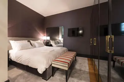 a bedroom with a large bed with a bench in it at Deco Gem Aliados in Porto