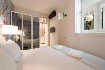 a bedroom with a large white bed and a window at Deco Gem Aliados in Porto