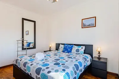 a bedroom with a bed with a blue and white comforter at Riverside City Centre Apartments in Porto