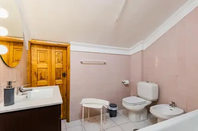 a bathroom with a white toilet and a sink at Riverside City Centre Apartments in Porto
