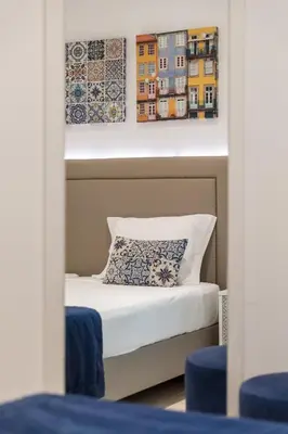 a bed in a room with two paintings on the wall at BRA.com Apartments Oporto Campanhã in Porto