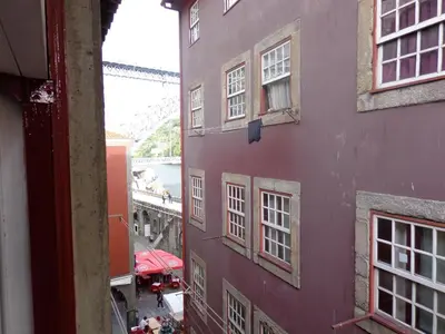 a purple building with white windows on a street at Ribeira Apartment in Porto