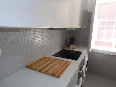 a kitchen with a wooden cutting board on the counter at Ribeira Apartment in Porto