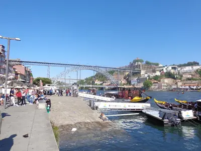 a group of people walking on a sidewalk next to a river at Ribeira Apartment in Porto