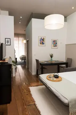 a living room with a bed and a dining room at Santo da Casa / Sc apartments in Porto