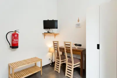 a room with a table and chairs and a fire extinguisher at Host Wise - Cozy Quiet Flat - Trindade Station in Porto