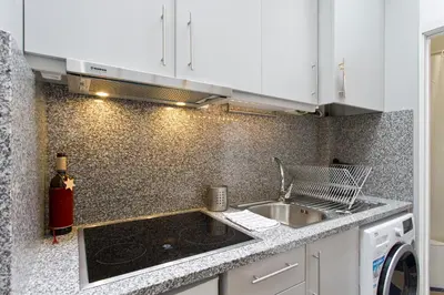a kitchen with a sink and a stove top oven at Host Wise - Cozy Quiet Flat - Trindade Station in Porto