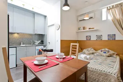 a small apartment with a table and a bed at Host Wise - Cozy Quiet Flat - Trindade Station in Porto