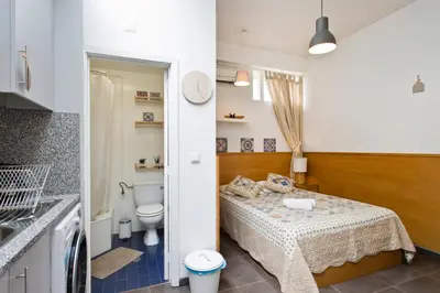 a bathroom with a bed and a toilet in a room at Host Wise - Cozy Quiet Flat - Trindade Station in Porto