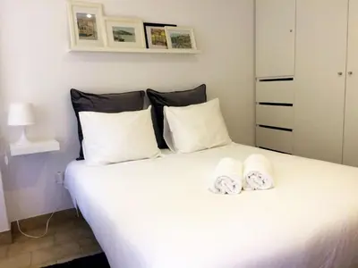 a bedroom with a large white bed with towels on it at Koka's Studio in Porto