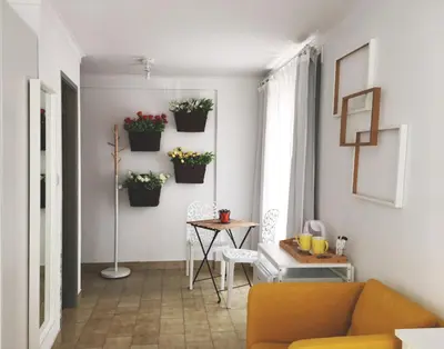 a living room with a couch and a table with flowers at Koka's Studio in Porto