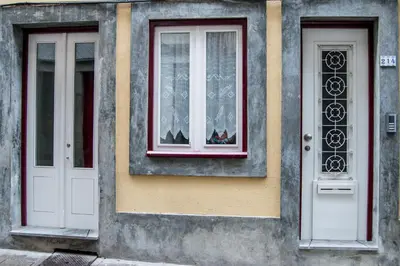 two white doors and a window on a building at KOKAS Apartments in Porto