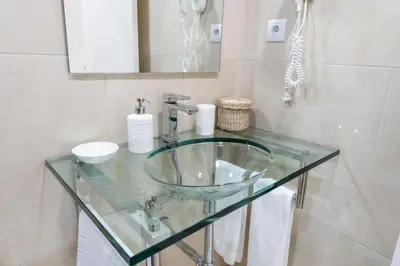 a bathroom with a glass sink and a mirror at Merc Porto Ribeira's View in Porto