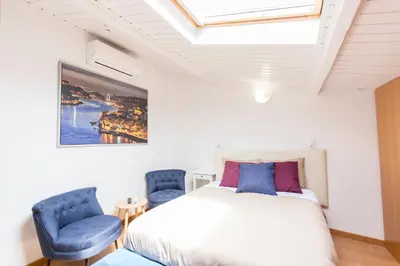a bedroom with a bed and two blue chairs at Porto 271 Mouzinho Apartamentos in Porto