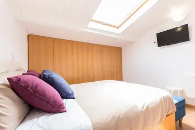 a bedroom with a white bed with colorful pillows at Porto 271 Mouzinho Apartamentos in Porto