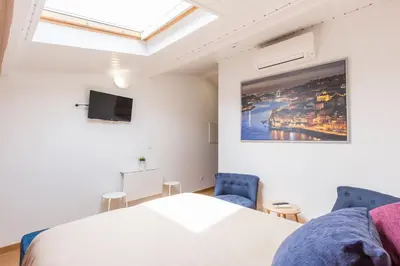 a bedroom with a bed and a skylight at Porto 271 Mouzinho Apartamentos in Porto