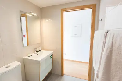 a white bathroom with a sink and a mirror at Porto 271 Mouzinho Apartamentos in Porto