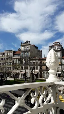 a white statue on a bridge with buildings in the background at OPorto Histórico - Galerias in Porto