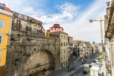 an old building with an arch in a city at Downtown Porto Mouzinho Studio Apts in Porto