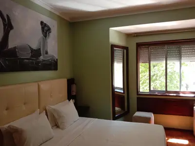 a bedroom with a white bed and a window at Faria Guimares Porto Centro in Porto