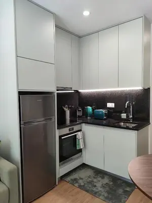 a kitchen with white cabinets and a stainless steel refrigerator at Suite na baixa do Porto in Porto