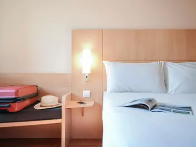 a hotel room with a bed with a straw hat on it at ibis Porto Centro São Bento in Porto
