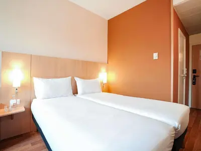a bedroom with a large white bed with two pillows at ibis Porto Centro São Bento in Porto
