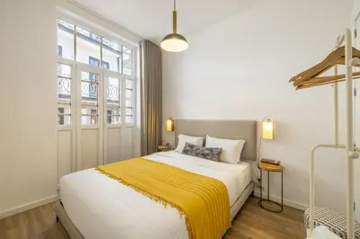 a bedroom with a large bed with a yellow blanket at D&S - Loureiro 67 in Porto